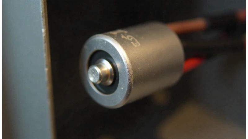 A close-up view of a furnace run capacitor, a common culprit in a furnace blower motor slow to start.