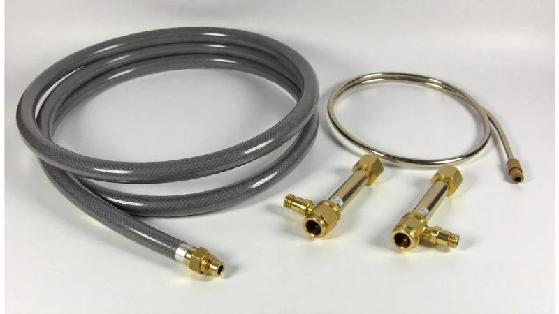 A natural gas conversion kit for a patio heater laid out on a clean surface, showing the hose, regulator, and brass fittings.