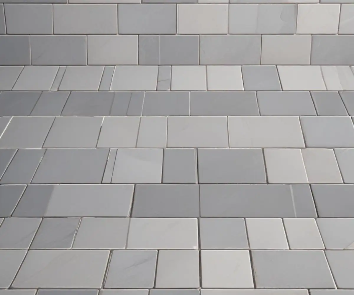 A close-up view of grey ceramic tiles with a uniform grout line separating them.