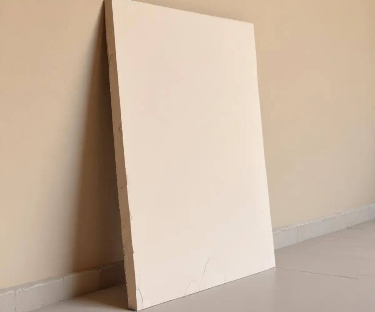 A smaller, half-sized sheet of gypsum board leaning against a wall.