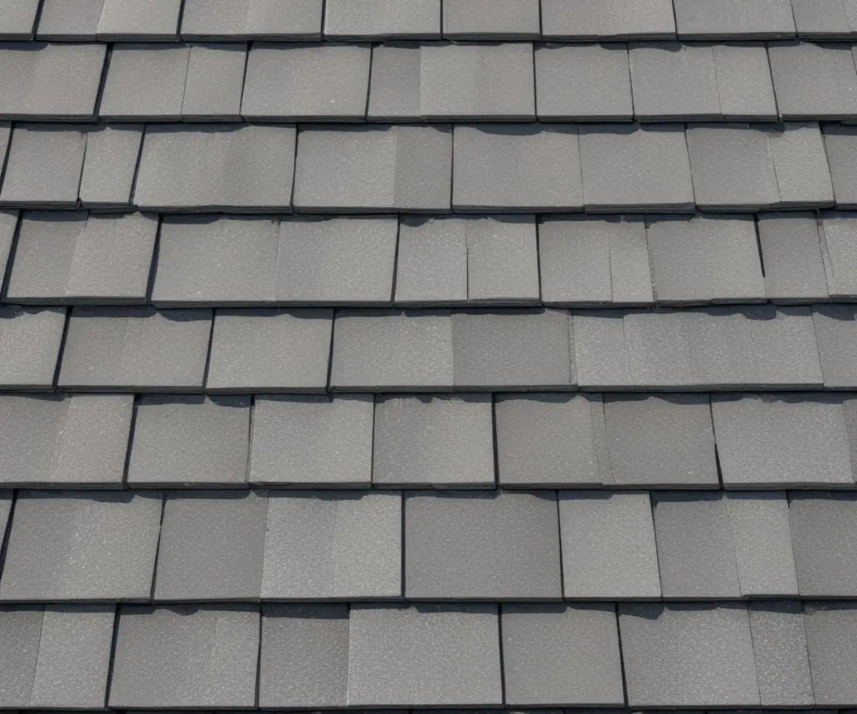 A single, gray asphalt roofing shingle on a clean, light-colored background.