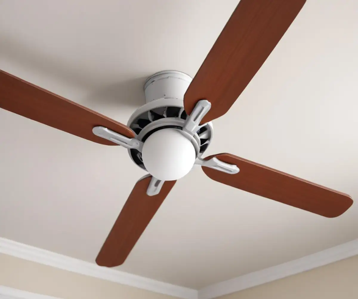A close-up of a metal ceiling fan ball joint against a plain white ceiling, showing the round ball and the top of the downrod.