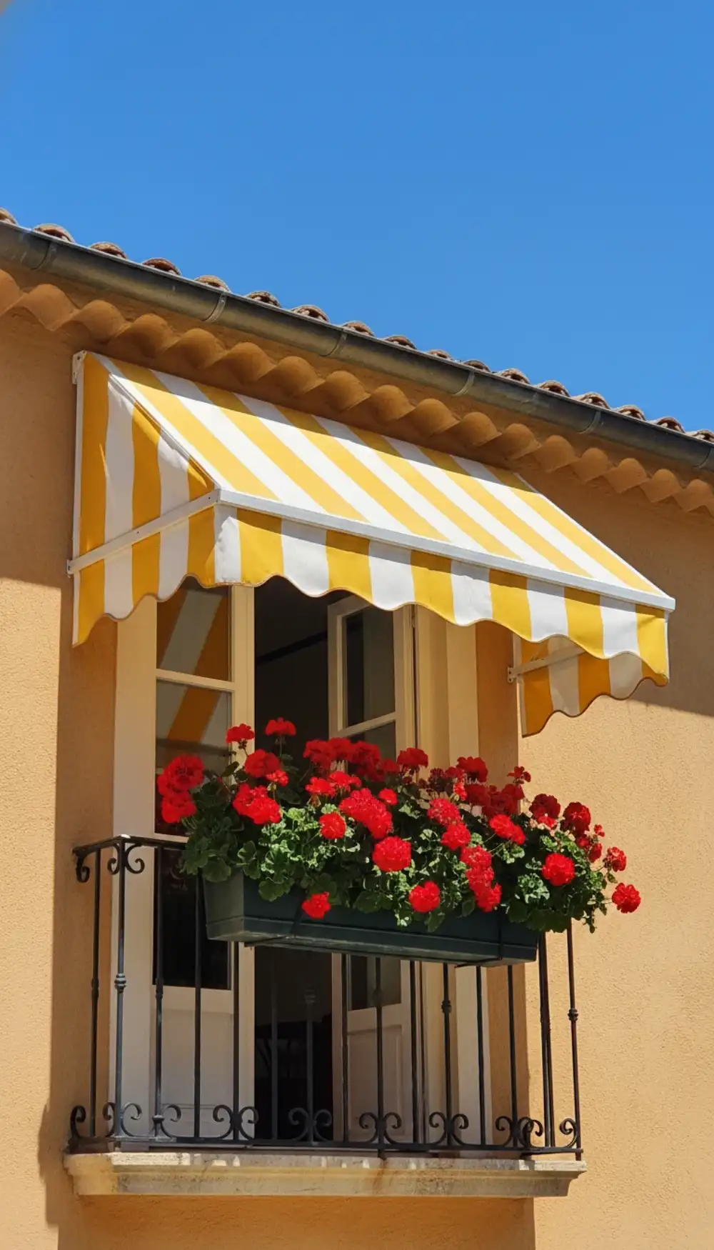 Bold yellow and white striped awning shading a balcony window