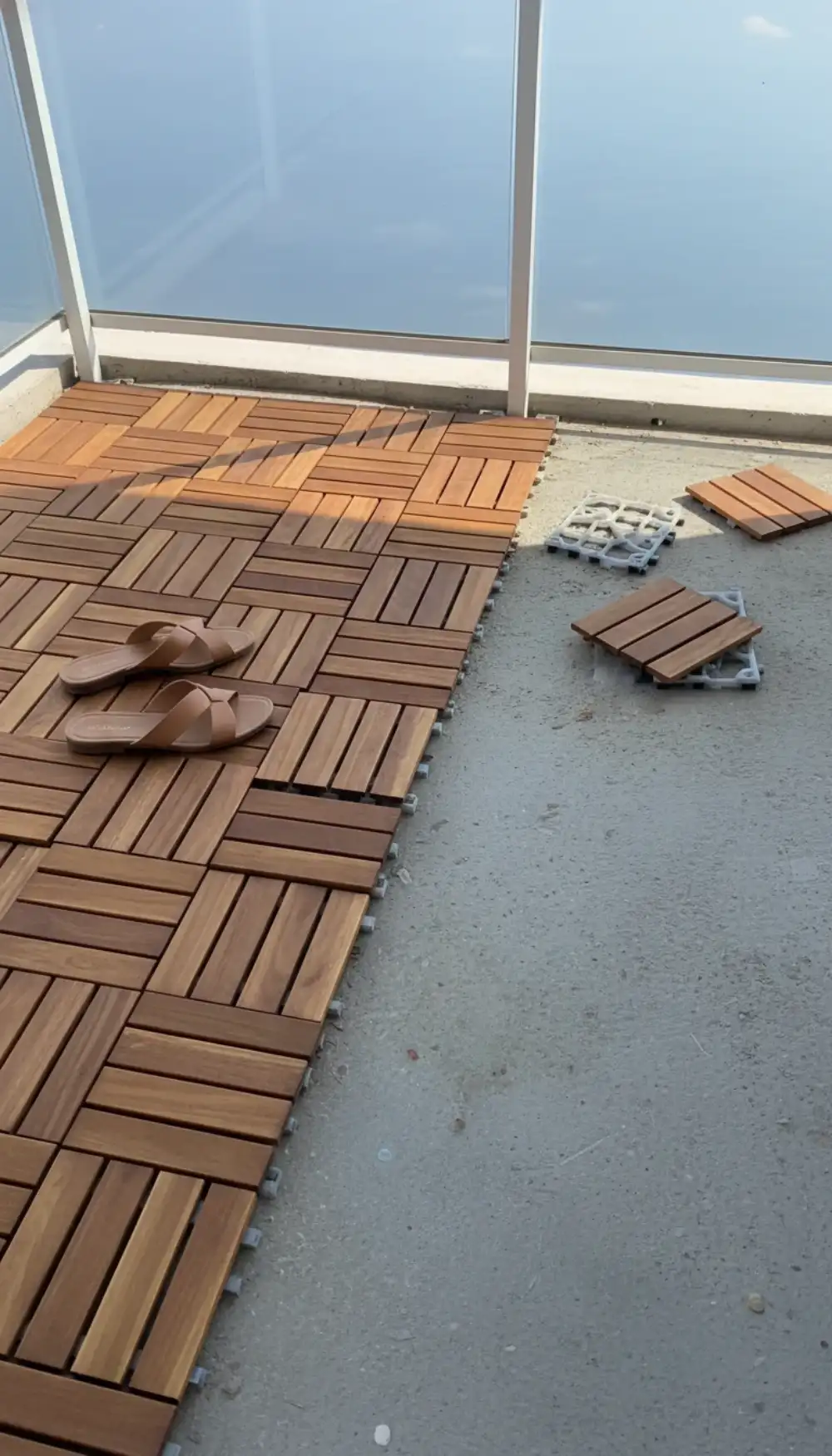Wood interlocking deck tiles covering a high-rise concrete balcony floor