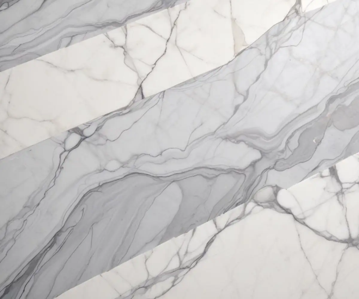 Close-up of a white and grey veined marble surface with a smooth, matte honed finish.