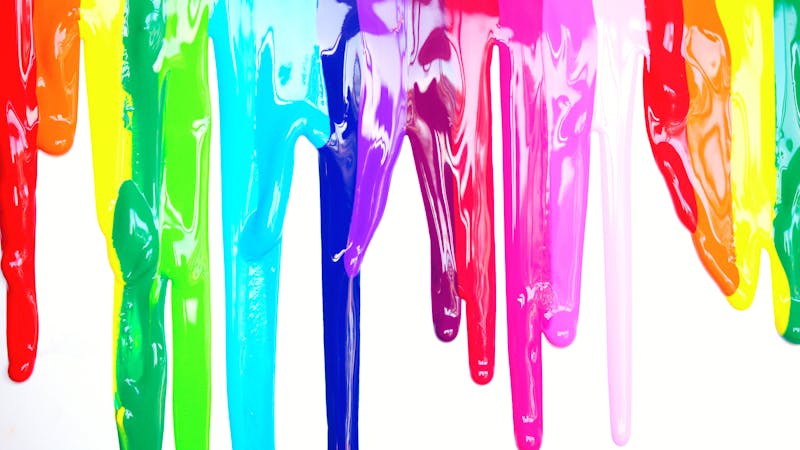 A vibrant selection of paint color swatches fanned out, showcasing various shades from light to dark on a paint store shelf.