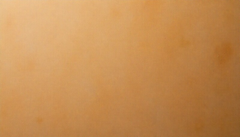 Close-up detail of a brown pressed wood fiber hardboard panel.