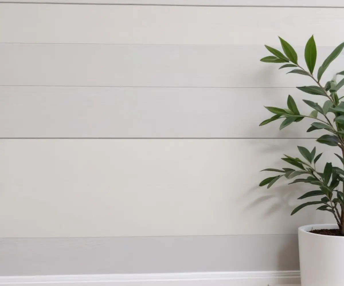 A close-up of a clean, seamless transition point between a white horizontal shiplap accent wall and a smooth, gray painted drywall surface in a modern home.