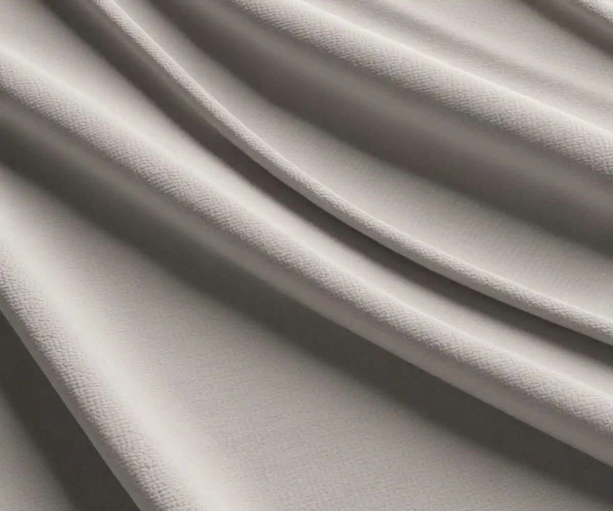 A close-up view of a durable, soft, woven chenille performance fabric in a light gray color.