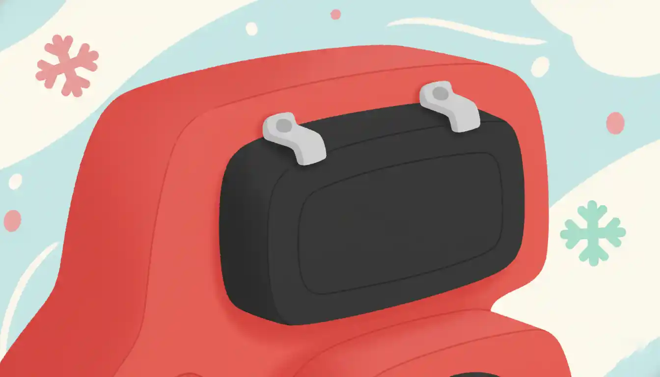 A close-up of a red snow blower engine, showing the black plastic air filter cover with locking tabs.