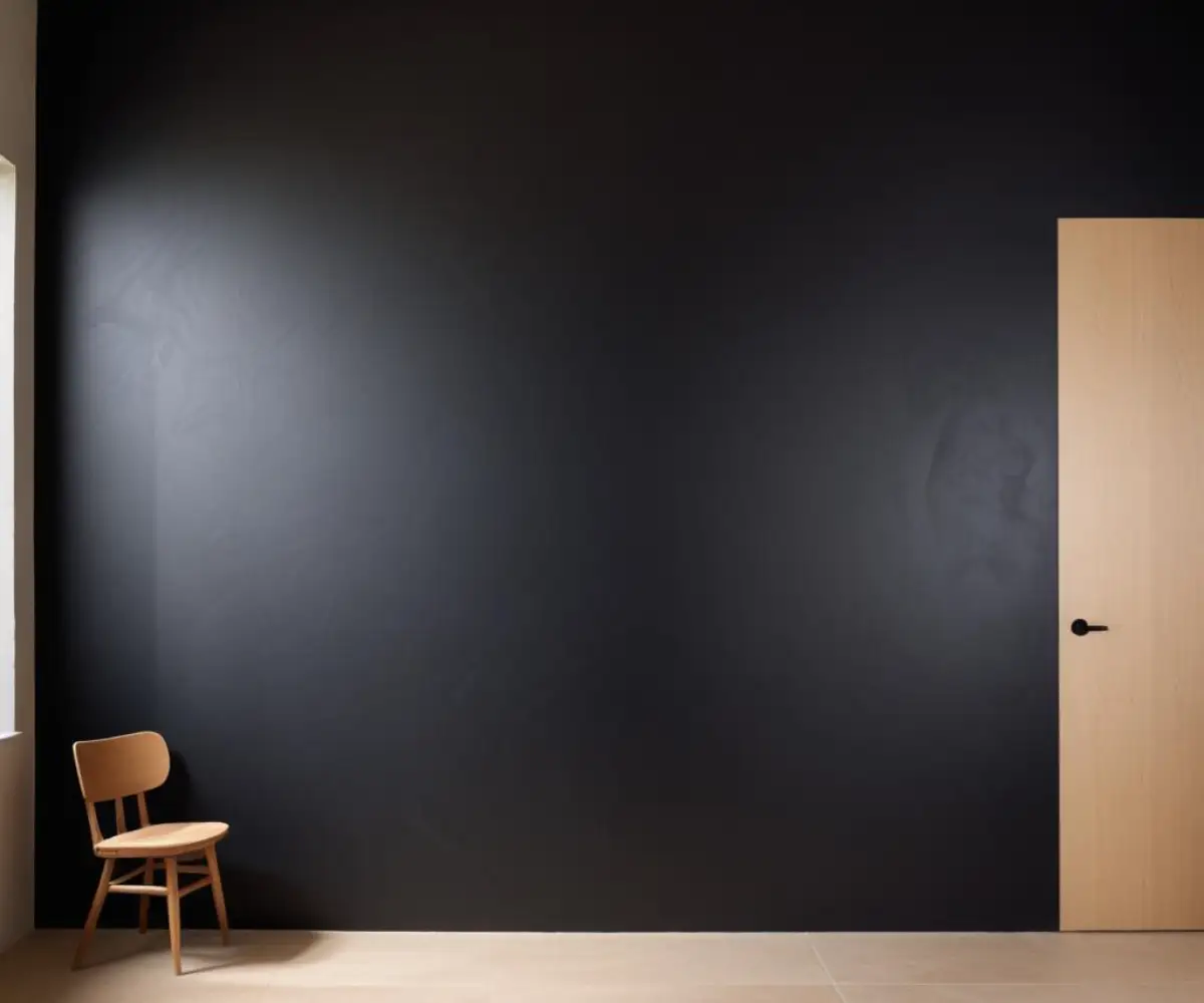 An interior wall coated in a smooth, non-reflective, ultra-black paint, creating a void-like effect where architectural details disappear.