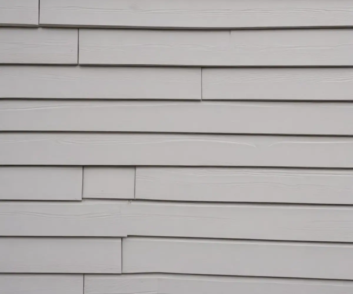 Close-up of overlapping light gray horizontal vinyl siding panels.